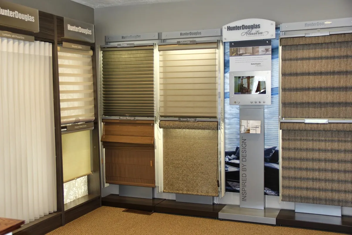 Showroom wall of working Hunter Douglas shade displays, labelled Luminette, Silhouette, Duette, Woven Textures, Screen Shades, Designer Roller Shades and Vignette